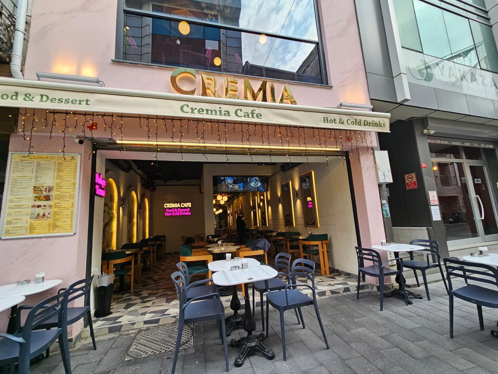 Cremia Cafe iç mekânı, akşam ışığında masalar